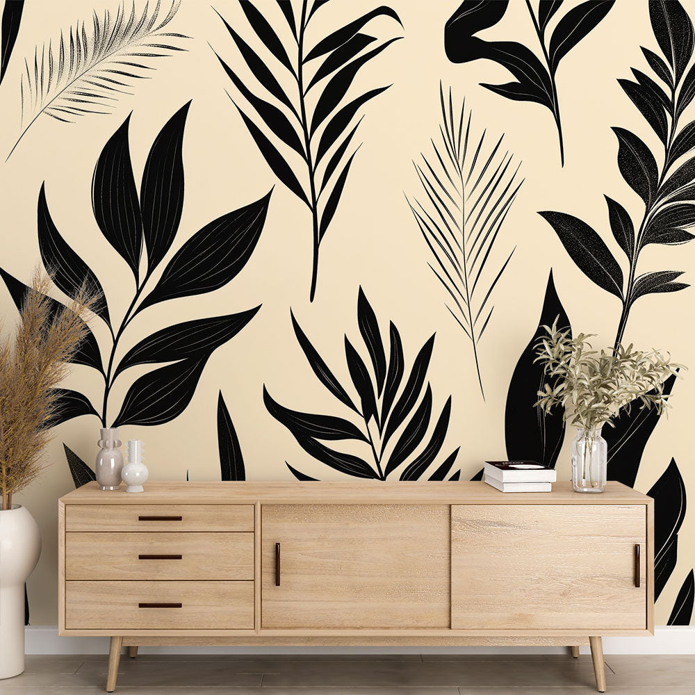 Black and beige tropical leaves wallpaper creating a modern accent wall in a bright minimalist living room setting