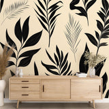 Black and beige tropical leaves wallpaper creating a modern accent wall in a bright minimalist living room setting