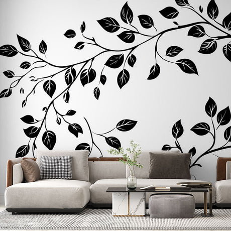 Black and white botanical wallpaper creating a striking feature wall in a modern living room with minimal furniture