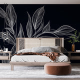 Black and white botanical leaf wallpaper creating a stunning focal point in a modern dining room with natural light