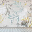 Botanical leaf wallpaper with blue and gold tones creating a calm atmosphere in a modern living room