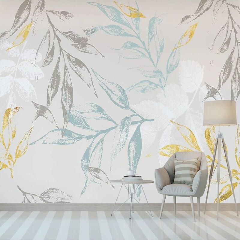 Botanical leaf wallpaper with blue and gold tones creating a calm atmosphere in a modern living room