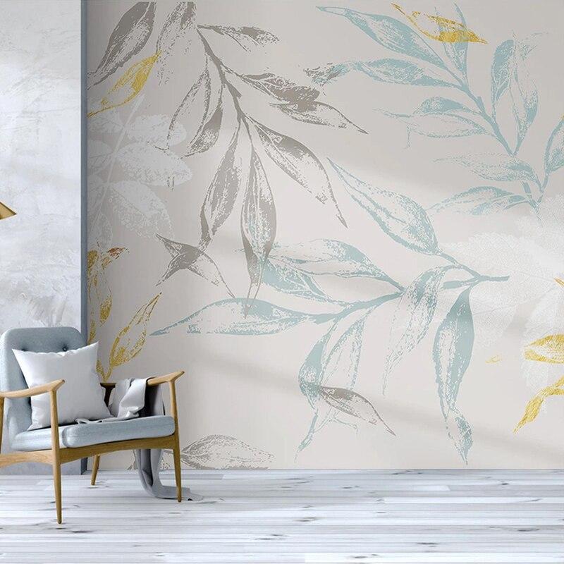 Nature-inspired wall mural with grey and gold leaves brightening a cozy bedroom space