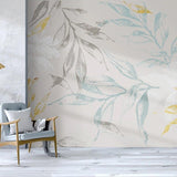 Nature-inspired wall mural with grey and gold leaves brightening a cozy bedroom space