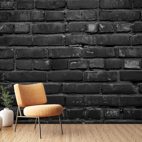 Black brick wallpaper creating dramatic accent wall in modern living room with grey sofa and metal accessories