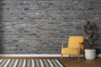 Industrial grey brick wallpaper in modern living room with leather sofa and metal accents