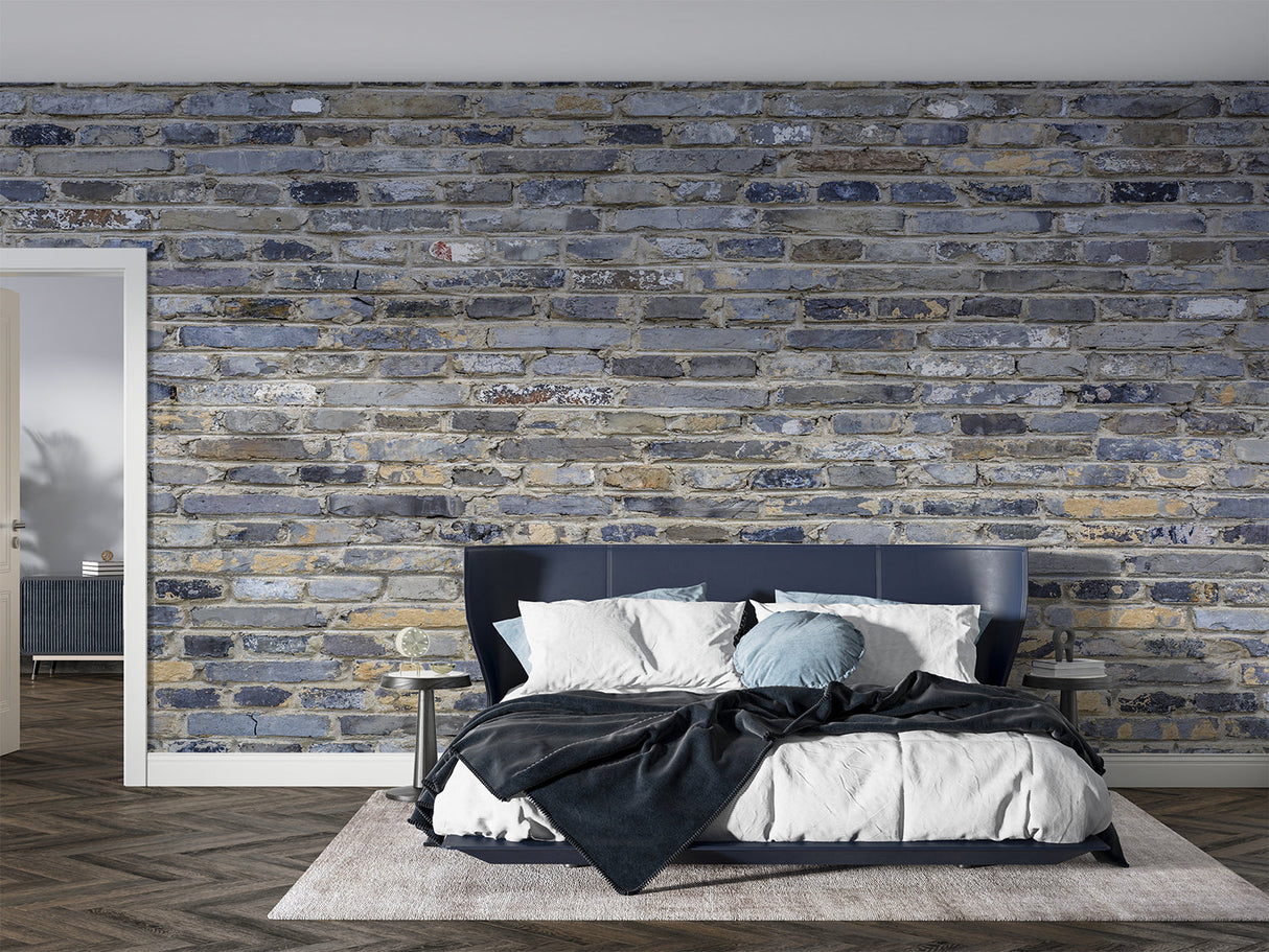 Industrial brick mural in loft bedroom with exposed metal fixtures