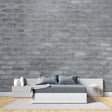Grey brick wallpaper in modern minimalist living room with leather sofa and industrial lighting