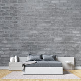Grey brick wallpaper in modern minimalist living room with leather sofa and industrial lighting