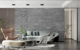Grey brick mural wallpaper in home office with modern desk and black accents