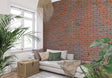 Red brick wall mural in modern living room with grey sofa and industrial lighting