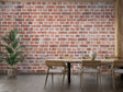 Vintage brick wallpaper creating an industrial feel in a modern living room with leather sofa