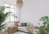 White brick wallpaper in modern living room with grey sofa and natural light