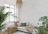 White brick wallpaper in modern living room with grey sofa and natural light