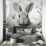 Black and white bunny wallpaper in modern nursery with white furniture