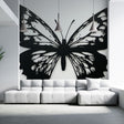 Modern black butterfly wallpaper mural creating drama in a bright living room with minimal furniture