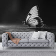 Black and white butterfly wall mural creating dramatic impact in modern living room with minimal furniture