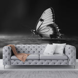 Black and white butterfly wall mural creating dramatic impact in modern living room with minimal furniture