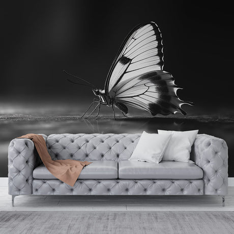 Black and white butterfly wall mural creating dramatic impact in modern living room with minimal furniture
