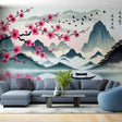 Cherry blossom wall mural creating depth in a modern living room, pink petals frame a serene mountain lake view