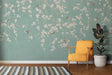 Cherry blossom wallpaper with birds shown in a bright living room, mint green walls creating a fresh spring atmosphere