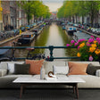 Amsterdam canal mural wallpaper creating depth in a bright modern living room with white furniture and natural light