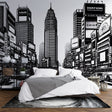 Black and white comic style city mural wallpaper in modern minimalist living room, creating dramatic urban atmosphere