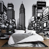 Black and white comic style city mural wallpaper in modern minimalist living room, creating dramatic urban atmosphere