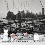 Black and white city mural of Brooklyn Bridge installed in industrial style dining room