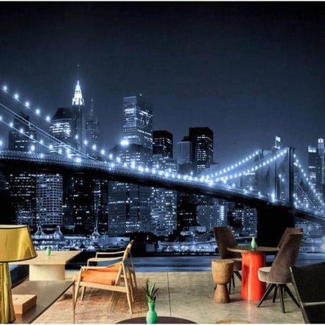 Brooklyn Bridge night skyline wallpaper in modern living room with gray sofa and ambient lighting