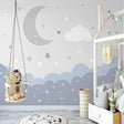Cloud nursery wallpaper with moon and stars bringing calm to a modern nursery with white furniture