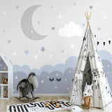 Moon and stars wallpaper creating a cozy reading nook in a toddler's bedroom