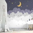 Cloud wallpaper mural with stars and moon creating a cozy atmosphere in a modern nursery with white furniture