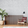 Modern concrete effect wallpaper in a minimalist living room with grey sofa and natural light