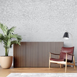 Modern concrete effect wallpaper in a minimalist living room with grey sofa and natural light