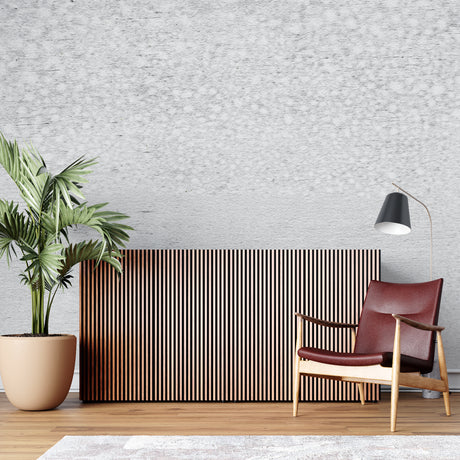 Modern concrete effect wallpaper in a minimalist living room with grey sofa and natural light