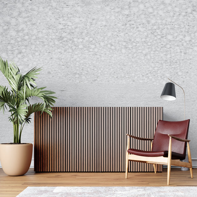 Modern concrete effect wallpaper in a minimalist living room with grey sofa and natural light