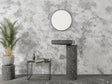 Modern concrete effect wallpaper in a minimalist living room with grey sofa and natural light