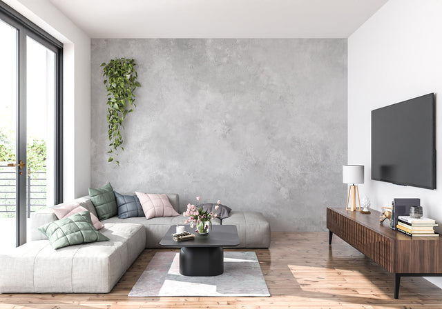 Modern concrete effect wallpaper in minimalist living room showing grey textured surface with natural lighting