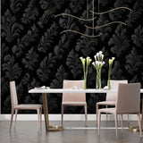 Master bedroom with black damask wallpaper creating dramatic accent wall behind bed