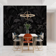 Black damask wallpaper creating elegant atmosphere in modern living room with gray sofa and brass accents