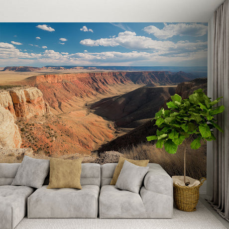 Desert canyon wallpaper mural showcased in a modern living room, red rock formations creating depth against white furniture