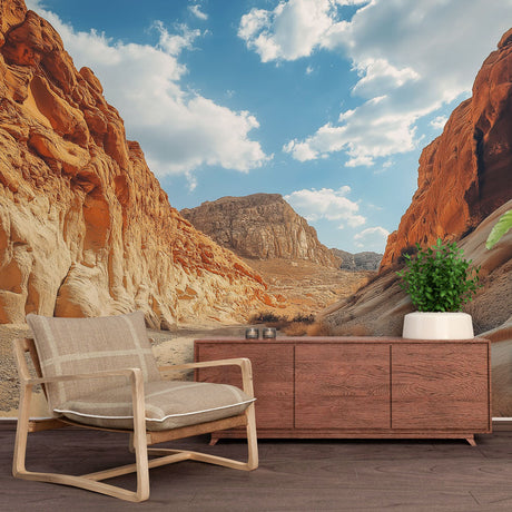 Desert canyon wall mural in modern living room, showing dramatic rock formations against blue sky creating depth and warmth