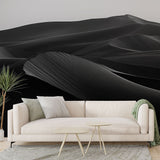 Black and white desert dunes wallpaper creating a dramatic focal point in a modern minimalist living room with clean lines