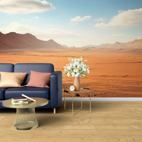 Desert landscape mural wallpaper styled in a modern living room, showing panoramic mountain vista against warm terracotta walls