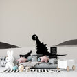 Modern black and white dinosaur wallpaper creating a peaceful atmosphere in a minimalist nursery with natural light