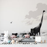 Black and white dinosaur wallpaper mural in modern nursery, showing diplodocus silhouette against peaceful savanna backdrop