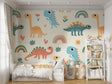 Pastel dinosaur nursery wallpaper in a bright, modern nursery with white furniture and rainbow accents
