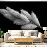 Black and white pampas grass wallpaper creating depth in a modern living room with minimal furniture