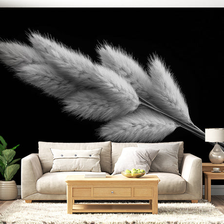 Black and white pampas grass wallpaper creating depth in a modern living room with minimal furniture